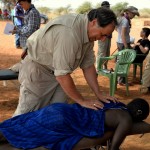 Jeff Kahrs, DC, adjusting the neck of a woman in Africa - 2014.